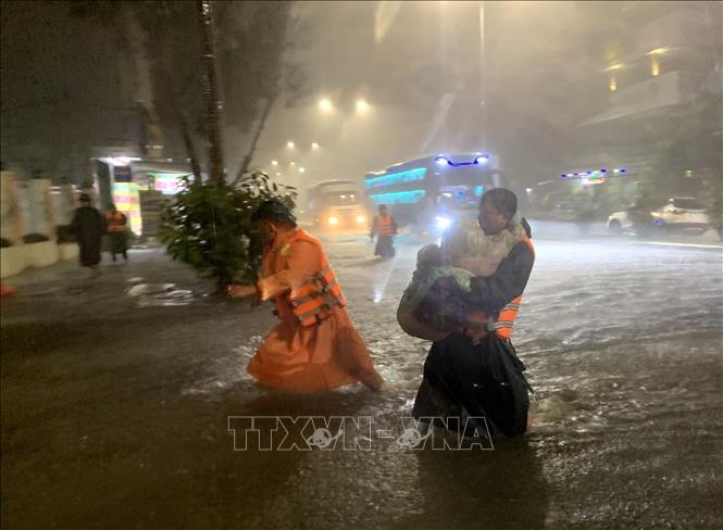 Lực lượng chức năng phường Hòa Khánh Nam (quận Liên Chiểu, Đà Nẵng) khẩn trương đưa trẻ em tại các hộ dân bị ngập đến nơi an toàn. Ảnh: TTXVN phát.