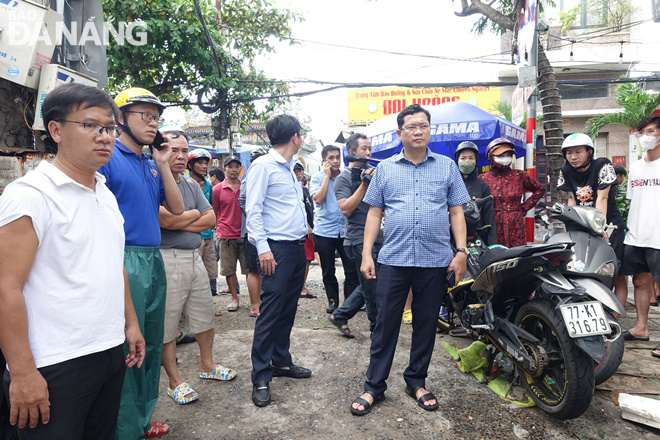 Phó Chủ tịch Trần Phước Sơn kiểm tra, chỉ đạo xử lý thoát nước và hỗ trợ nhân dân ở khu vực kiệt của đường Thái Thị Bôi đang bị ngập sâu. Ảnh: HOÀNG HIỆP