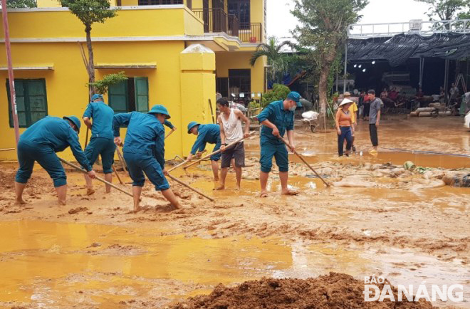 Các lực lượng chức năng của quận Cẩm Lệ xúc dọn bùn, đất trên một đoạn đường.