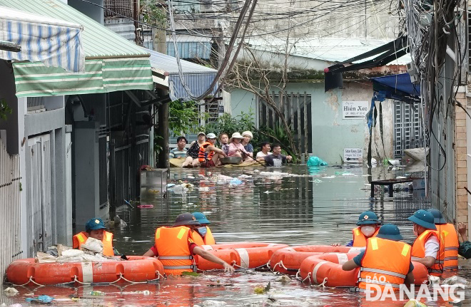 Shock forces in Chinh Gian Ward, Thanh Khe District, supporting residents in a deeply flooded alley on ​​Thai Thi Boi Street on the afternoon of October 15.