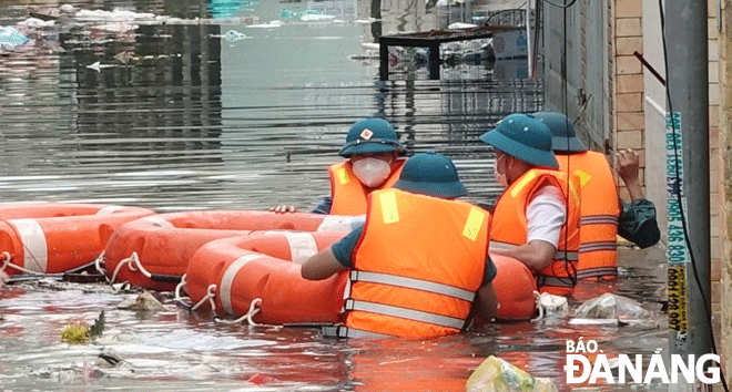 Lực lượng xung kích phường Chính Gián, quận Thanh Khê đến hỗ trợ người dân ở khu vực kiệt đường Thái Thị Bôi bị ngập sâu vào chiều 15-10. Ảnh: HOÀNG HIỆP