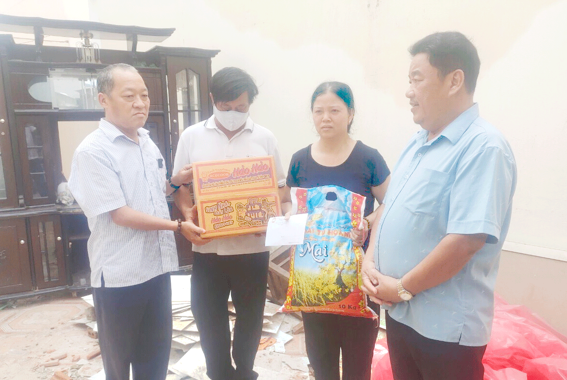 Chủ tịch Ủy ban MTTQ Việt Nam phường An Hải Bắc Lê Bá Công (bên trái) trao hỗ trợ cho hộ dân có nhà bị tốc mái do bão số 4 gây ra. Ảnh: Mặt trận phường cung cấp