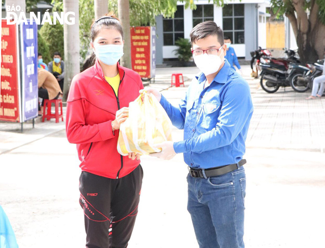 Anh Bùi Đăng Toản (phải) trao quà cho sinh viên khó khăn. Ảnh: HỒNG QUANG