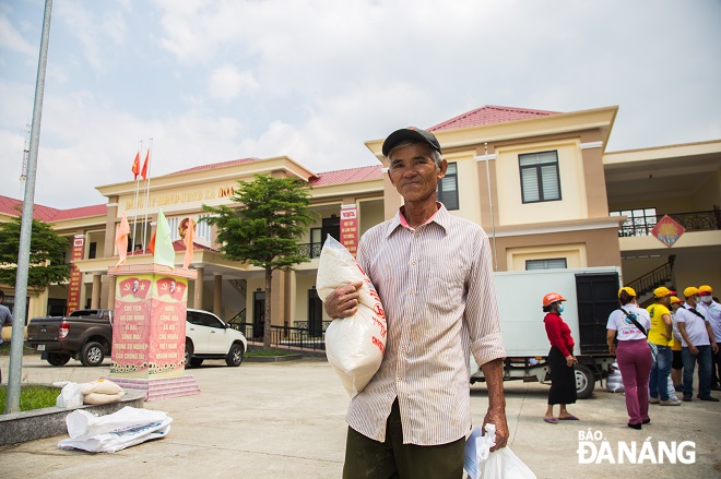 Người đàn ông tại xã Hoà Nhơn vui mừng khi được cấp phát gạo, đồ gia dụng cũng như là tiền mặt hỗ trợ sau khi gia đình ông thiệt hại nặng nè trong mùa mưa lũ năm nay.