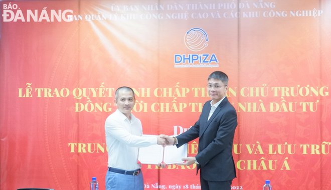 Mr. Pham Truong Son, Head of the DHPIZA (right) presents an investment policy decision for the ASIA HIGH TECH., JSC.-developed Tissue-Stem Cell Research and Storage Centre project in the Da Nang Hi-tech Park. Photo: M.Q