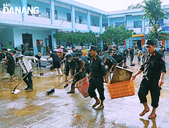 Nhiều đơn vị hỗ trợ Trường Tiểu học Hồng Quang (quận Liên Chiểu) dọn dẹp bùn non chiều 17-10. Ảnh: NGỌC HÀ