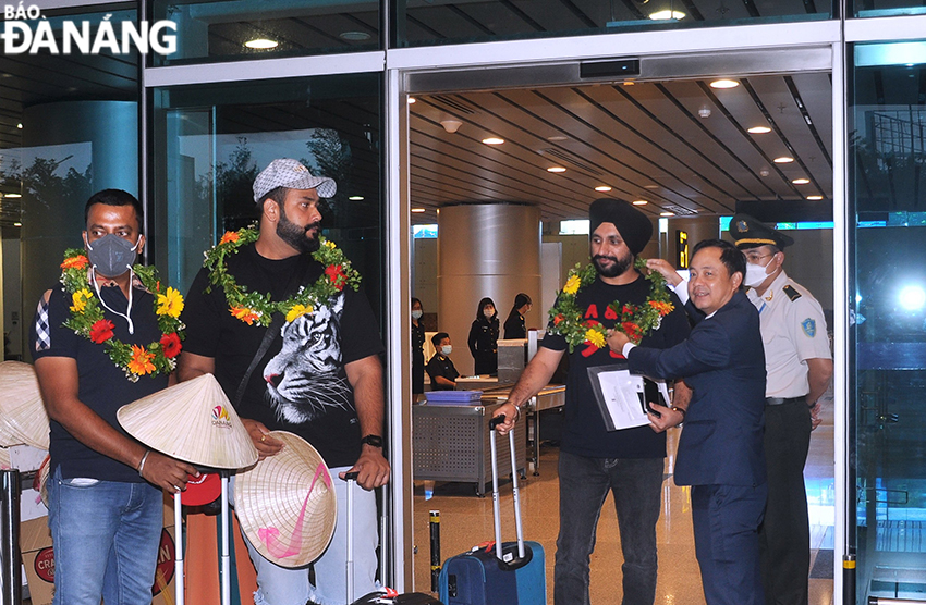 Deputy Director of the Da Nang Department of Tourism Nguyen Xuan Binh (right) presenting welcome flowers to Indian guests on the first flight to Da Nang from New Delhi. Photo: THU HA