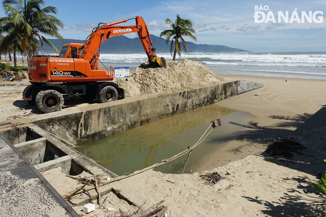 The Da Nang Sewerage and Wastewater Treatment Company on Thursday used motor vehicles to remove sand that blocked the valve gates at the My An Sluice Gate after heavy rain lashed the city on October 14 in order to prepare for more downpours and prevent flooding in The An Thuong Tourism Area. Photo: HOANG HIEP