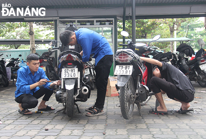Đội phản ứng nhanh SOS - Đoàn Trường Đại học Đông Á tham gia sửa chữa xe máy miễn phí giúp sinh viên, người dân trong khuôn viên nhà trường. Ảnh: XUÂN ĐÔNG	