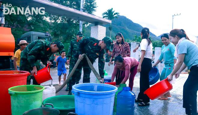 Người dân thôn Tà Lang, xã Hòa Bắc, huyện Hòa Vang đến lấy nước sạch từ xe bồn của Cục hậu cần, Quân khu 5. Ảnh: P.V