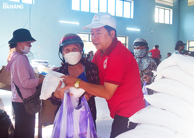 Volunteers of the Da Nang Red Cross Society presenting gifts to flood-affected residents to encourage them to soon overcome flooding-triggered difficulties.