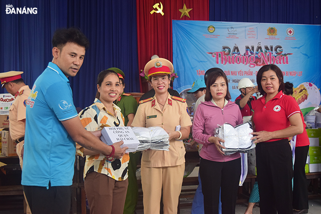 Chairwoman of the municipal Red Cross Society Le Thi Nhu Hong (first, right) and sponsors presenting gifts to the Hong Quang Primary School representative (second, right).