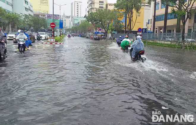 Heavy rain leaves Nguyen Van Linh Street under water. Photo: HOANG HIEP