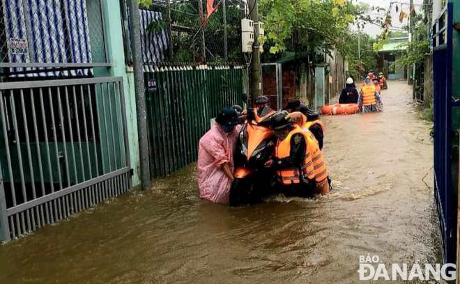 Lực lượng cứu hộ phường Hòa Khánh Nam (quận Liên Chiểu) hỗ trợ người dân đi dơ tán và di chuyển phương tiện ra khỏi khu vực bị ngập sâu do ảnh hưởng của quy hoạch 