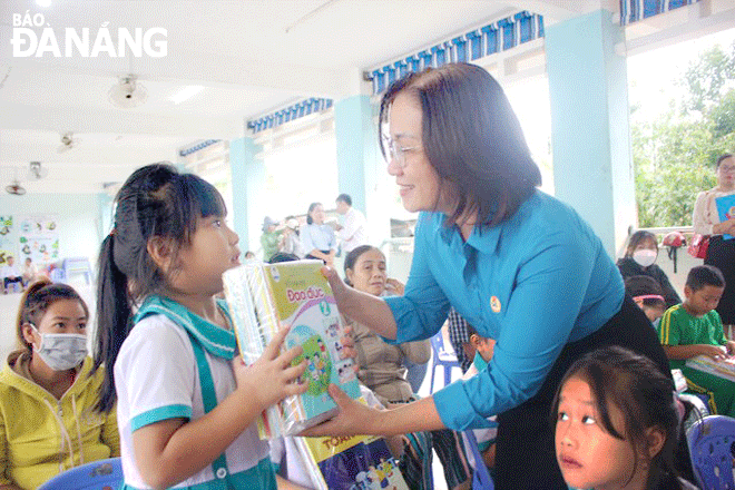 Vice President of the Da Nang Labour Federation Dinh Thi Thanh Ha presents textbooks to students at the Hong Quang Primary School, Hoa Khanh Nam Ward, Lien Chieu District. Photo: THANH GIANG