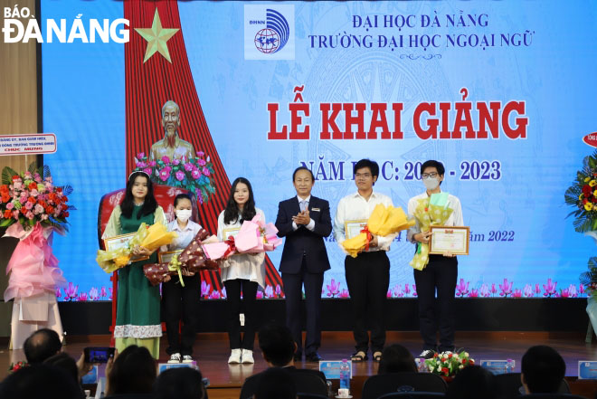 Leader of the University of Foreign Language Studies - the University of Da Nang  presenting scholarships to 5 students with the highest enrollment scores in the 2022-2023 academic year. Photo: NGOC HA