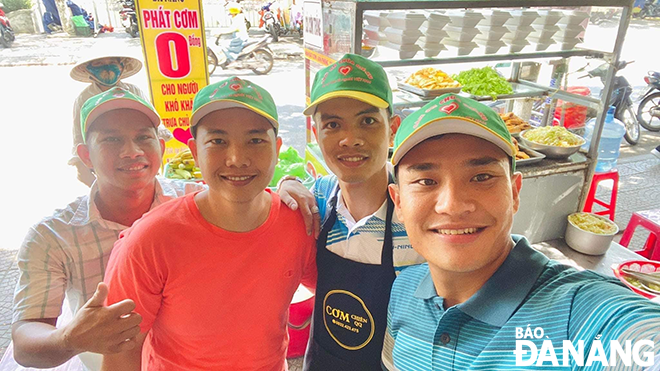 Nguyen Tran Quan and Le Than Nhu Phuong (right) and members of the 'Rebirth' charity group giving free meals to the needy. Photo: H.T.V