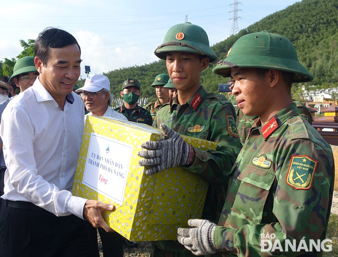 Chủ tịch UBND thành phố Lê Trung Chinh (bìa trái) tặng quà cho đại diện các đơn vị quân đội tham gia khắc phục sạt lở tại nghĩa trang Hòa Sơn.