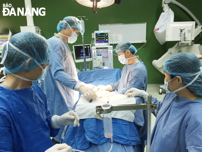 Surgeons from the Da Nang Hospital performing a bone marrow transplant surgery due to a spinal injury for a patient. Photo: PHAN CHUNG