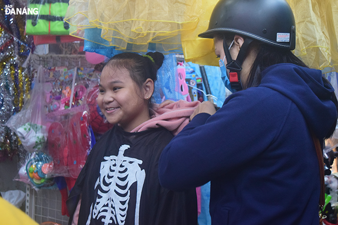 Nguyen Ngoc Bao Anh, a pupil of grade 5/1 from the Hai Chau District-based Vo Thi Sau Primary School, is choosing costumes for her school's Halloween. 