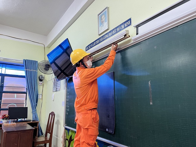 Công nhân Điện lực Hải Châu thay thế miễn phí bóng đèn tiết kiệm điện tại Trường Tiểu học Bạch Đằng.