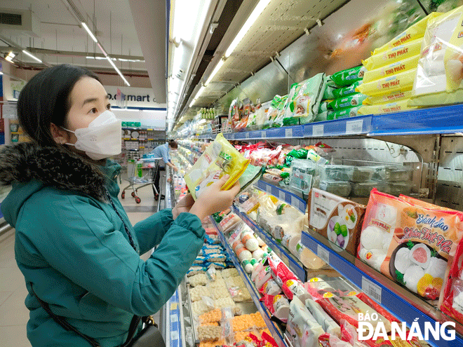 A number of Tet goods have hit supermarket shelves. IN PHOTO: A shopper at the Co.opmart Da Nang. Photo: QUYNH TRANG