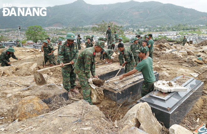 Nhiều phần mộ bị vùi lấp ở nghĩa trang Hòa Sơn đang được cán bộ, chiến sĩ phát lộ. 