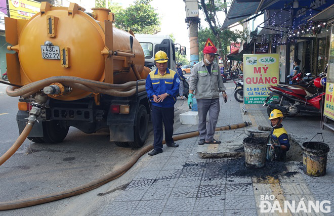 Công nhân Công ty Thoát nước và xử lý nước thải Đà Nẵng nạo vét hố ga, cống thoát nước dọc đường Hà Huy Tập.