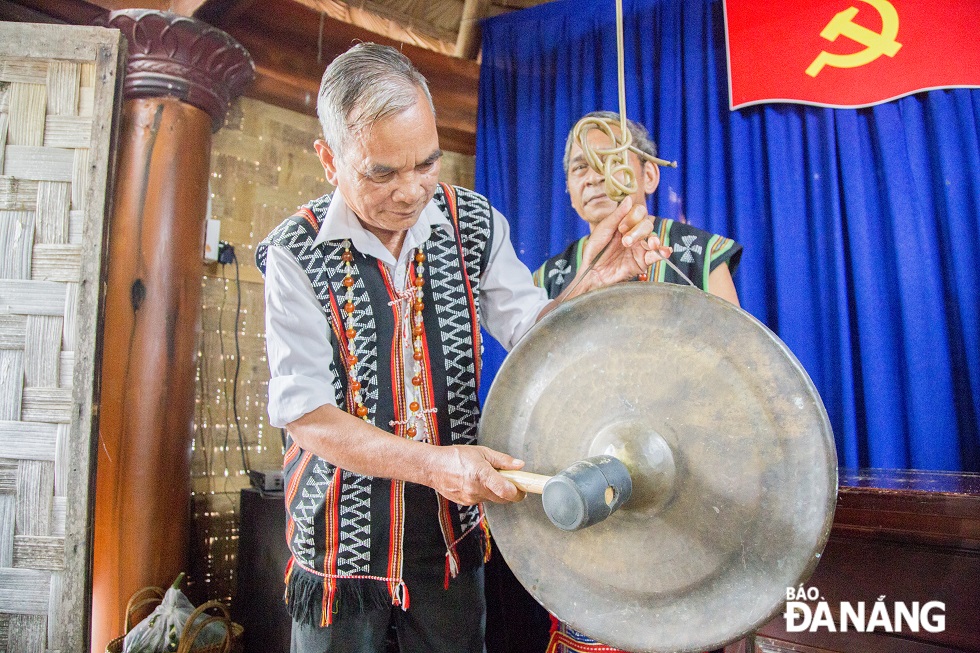 A village elder playing 'gong' to celebrate the brotherhood ceremony