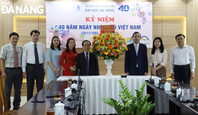 Chủ tịch UBND thành phố Lê Trung Chinh tặng hoa chúc mừng Đại học Đà Nẵng. Ảnh: NGỌC HÀ
