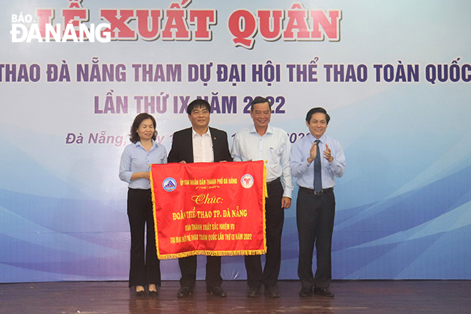 Thừa ủy quyền của lãnh đạo thành phố, Giám đốc Sở Văn hóa và Thể thao Phạm Tấn Xử (bìa phải) trao cờ chúc mừng đoàn thể thao thành phố. Ảnh: P.N