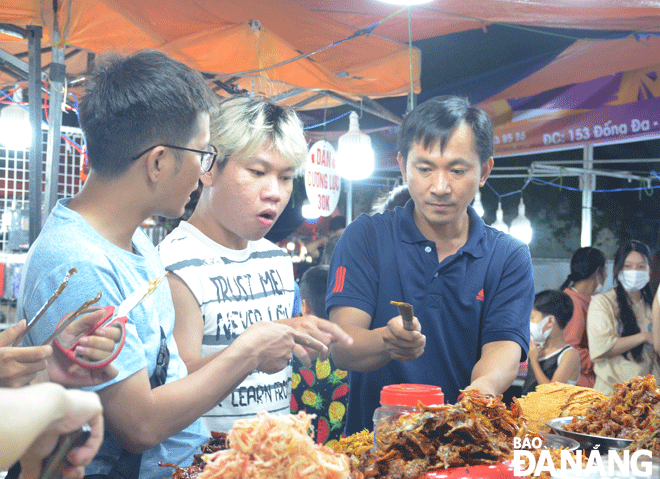 Son Tra District is giving high priority to developing new tourism products and services to turn tourism into a spearhead economic sector. In the photo: Tourists do shopping at the Son Tra Night Market. Photo: THU HA