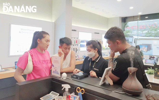 Many tech products and services are launched at the year-end period, attracting the attention of many tech lovers.  Customers are pictured experiencing tech products at a store on Vinh Trung Ward, Thanh Khe District, Da Nang. Photo: CHIEN THANG