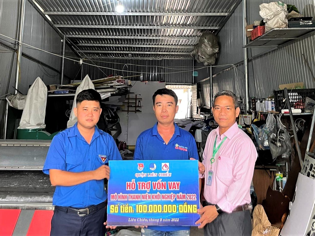 A young Da Nang man (centre) receives a bank loan at highly preferential interest rate to start his own business. Photo: LAM PHUONG