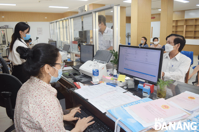 Từ cơ sở dữ liệu đất đai đã được số hóa, chuyên viên Chi nhánh Văn phòng Đăng ký đất đai quận Sơn Trà giải quyết hồ sơ cấp giấy chứng nhận quyền sử dụng đất trực tuyến cho  công dân. Ảnh: HOÀNG HIỆP