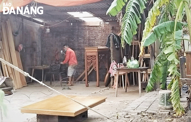 Nhân viên tại cơ sở gia công gỗ ở cạnh số 6 An Hải Bắc 2 (phường An Hải Bắc, quận Sơn Trà) phun PU gây mùi hôi. Ảnh: YÊN GIANG