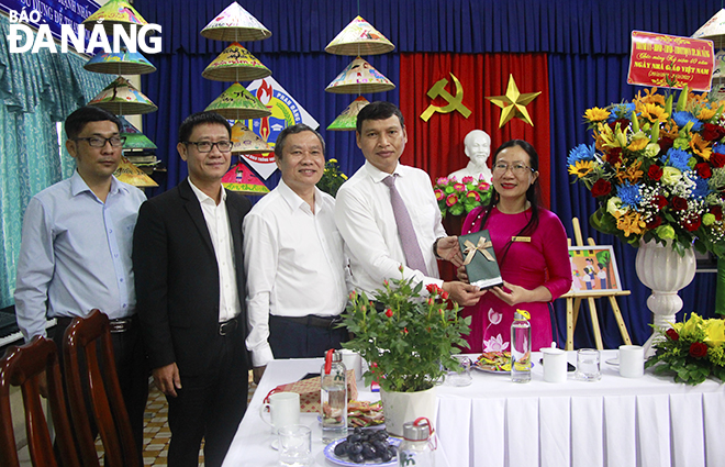 Phó Chủ tịch Thường trực UBND thành phố Hồ Kỳ Minh (thứ 2, bên phải qua) tặng quà chúc mừng ngày Nhà giáo Việt Nam cho Trường Tiểu học Phan Đăng Lưu. Ảnh: XUÂN DŨNG