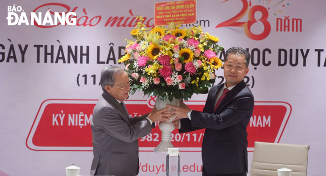 Da Nang Party Committee Secretary Nguyen Van Quang (right) presenting flowers to the Labour Hero, EliteTeacher Le Cong Co, a representative of the Duy Tan University, to on the Vietnamese Teachers' Day. Photo: PHAN CHUNG
