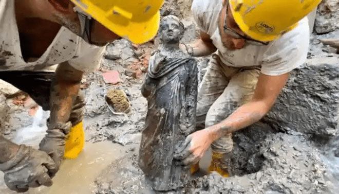Các nhà khảo cổ đang lau chùi tượng được phát hiện tại khu nước nóng cổ ở Tuscany, Ý.