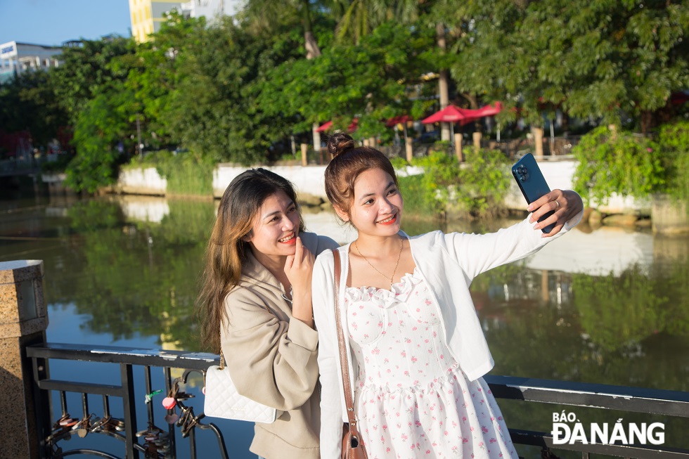 Two girls take selfie in the early morning sunshine at the Bridge of Love