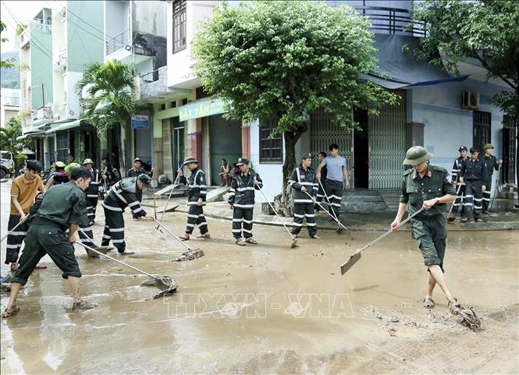 Lực lượng Cảnh sát cơ động tham gia dọn dẹp, vệ sinh lại nhiều đoạn đường tại Phường Ghềnh Ráng,TP Quy Nhơn, Bình Định. Ảnh: TTXVN phát