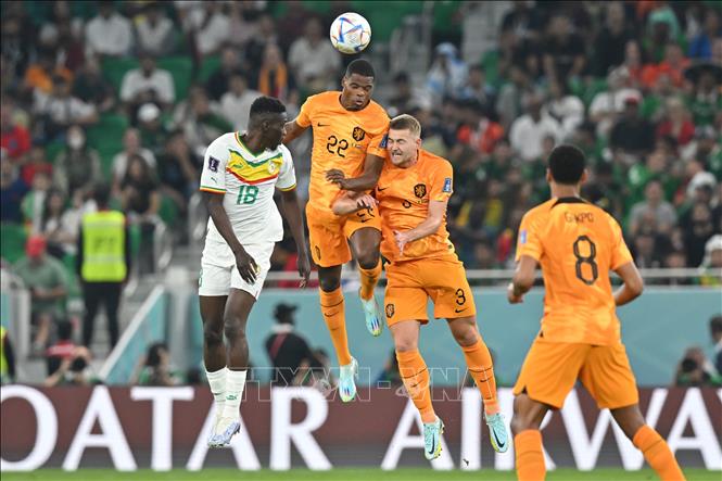 Pha tranh bóng bổng quyết liệt của cầu thủ 2 đội trong trận đấu trên sân vận động Al-Thumama, tại thủ đô Doha (Qatar) ngày 21/11. AFP/TTXVN