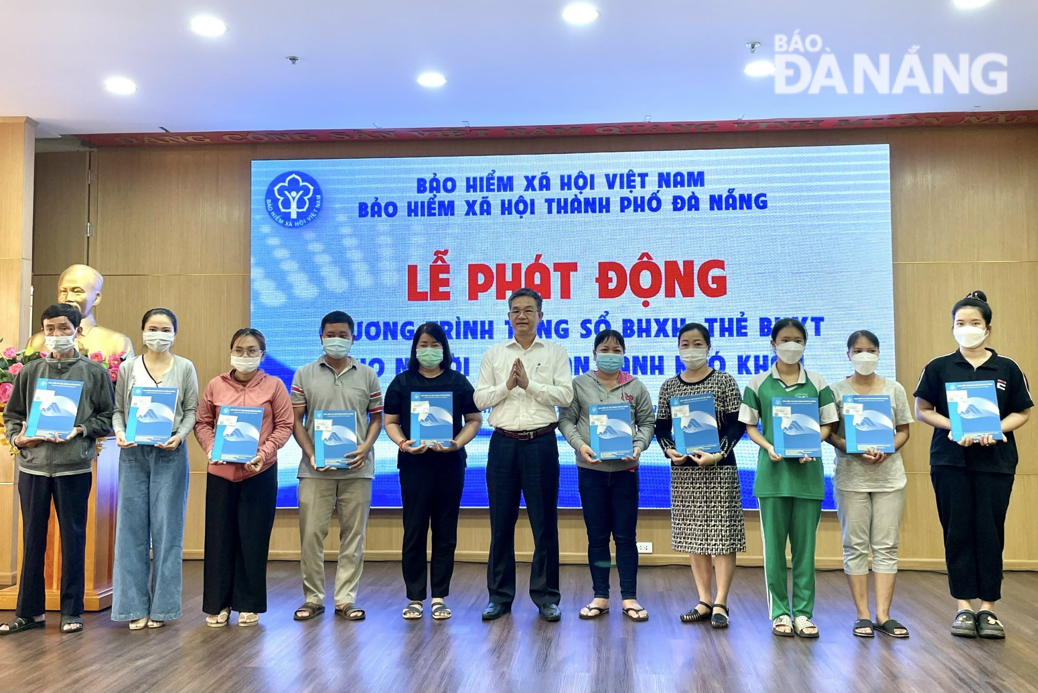 Phó Giám đốc BHXH thành phố Nguyễn Hùng Anh (ở giữa) trao thẻ BHYT cho người nghèo có hoàn cảnh khó khăn. Ảnh: N.QUANG