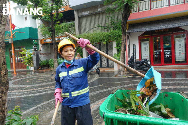 Chị Trần Thị Nở luôn cố gắng hoàn thành công việc, giữ gìn cảnh quan phố du lịch An Thượng. Ảnh: CAO MINH