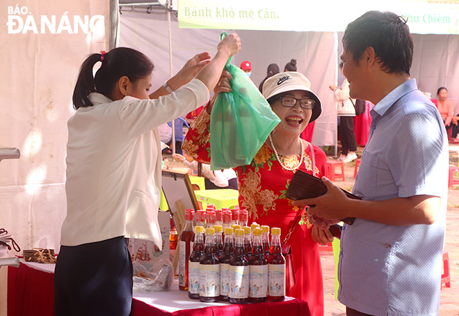 Visitors to the stall displaying Nam O fish sauce