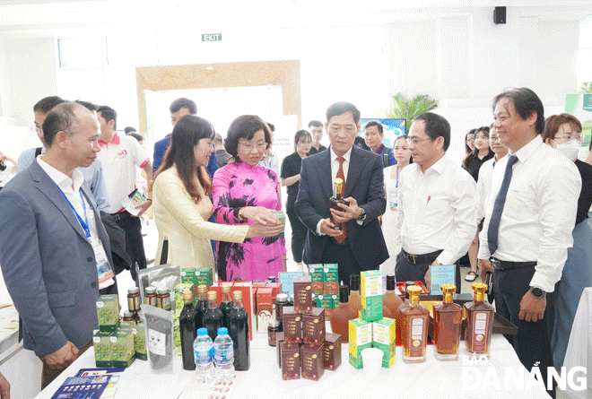 Thứ trưởng Bộ Khoa học và Công nghệ Trần Văn Tùng (thứ 4, bên trái sang) và Phó Chủ tịch UBND thành phố Ngô Thị Kim Yến (thứ 3, bên trái sang) tham quan các gian hàng tại triển lãm. Ảnh: M.Q