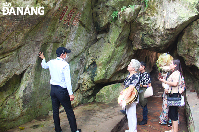 A tour guide introducing visitors to the 'Ma Nhai' system at the Marble Mountains. Photo: X.D