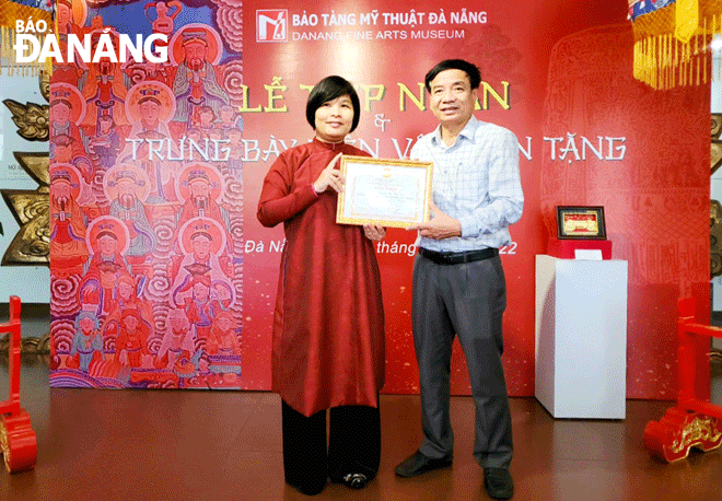 Deputy Director of the Da Nang Department of Culture and Sports Ha Vy (right) presents a certificate of merit to researcher and collector Nguyen Thi Thu Hoa in recognition for her outstanding donations to the Da Nang Fine Arts Museum. Photo: X.D