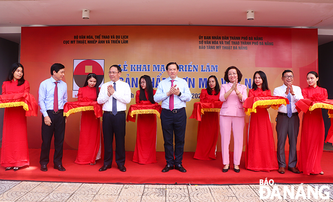  Deputy Minister of Culture, Sports and Tourism Ta Quang Dong (centre) and Da Nang People's Committee Vice Chairwoman Ngo Thi Kim Yen (second, right) cutting the ribbon to open the exhibition. Photo: X.D