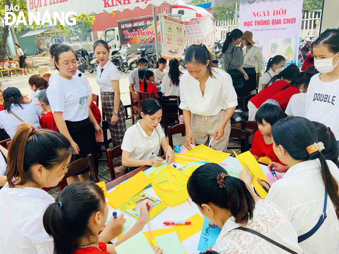 Giáo viên cùng phụ huynh và học sinh Trường Tiểu học Hồng Quang (quận Liên Chiểu) tham gia ngày hội học thông qua chơi. Ảnh: T.V